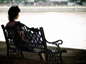 woman sitting alone on a bench