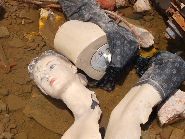 a broken manequin in the dirt