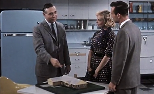 Two men and a woman standing in a kitchen