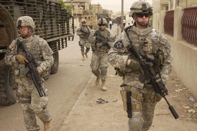 Soldiers walking towards the camera with guns