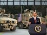 Obama giving a speech in front of tanks