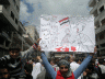 A man holds up a political cartoon at a Syrian protest in May 2011